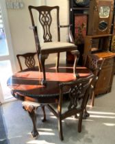 A Mahogany extending dining table with additional leaf and 5 dining chairs.