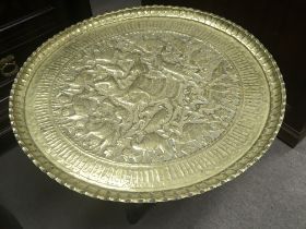 A Middle Eastern brass tray topped occasional table with a folding stand diameter 63cm