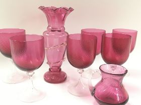 A collection of cranberry glass including vases and a set of 6 cranberry wine glasses. Postage