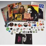 A collection of mostly music-related pin badges plus three copies of The Face, tour programmes,