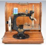 Vintage Lead toy sewing machine, in original wooden case