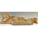 Large carved wooden figure of a young reclining Buddha, with jewelled decoration, height 21 x length