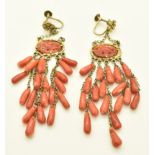 A pair of Chinese silver earrings set with carved coral depicting a bird, with coral drop