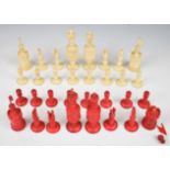 A carved bone chess set with one side stained red, height of king 13cm.