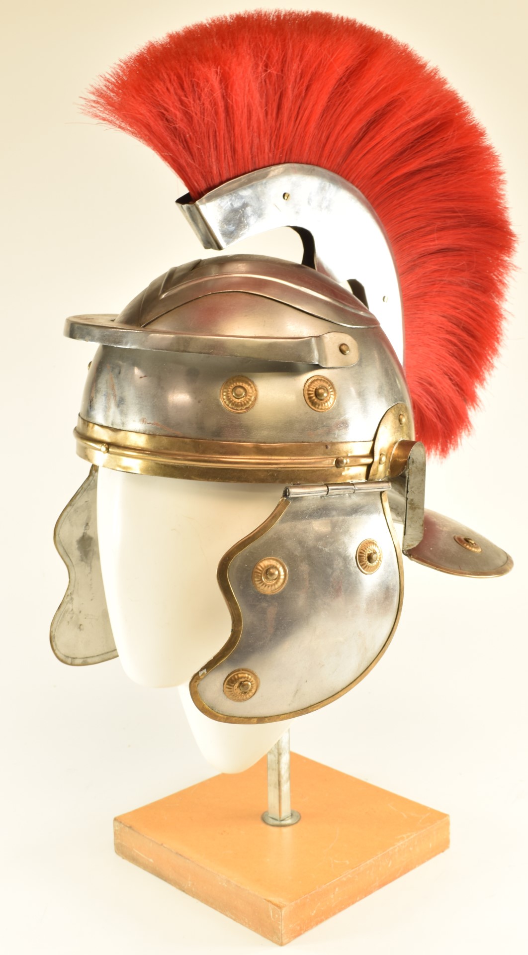 Replica Roman Centurion's steel helmet with red plume, brass edging and rosettes and leather lining.