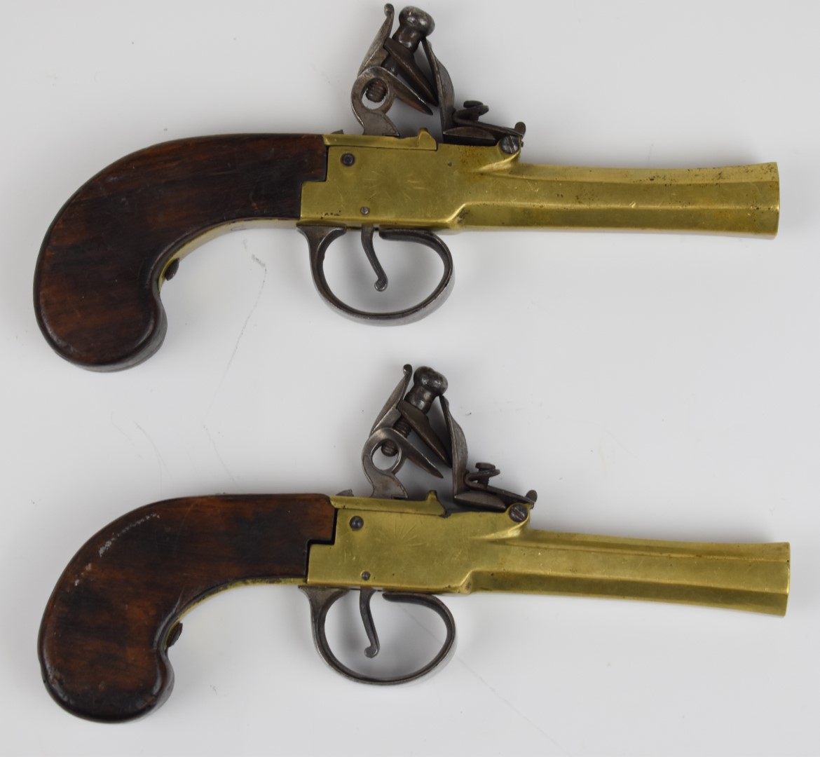 A pair of unnamed flintlock pocket pistols each with brass body, engraved locks, steel trigger