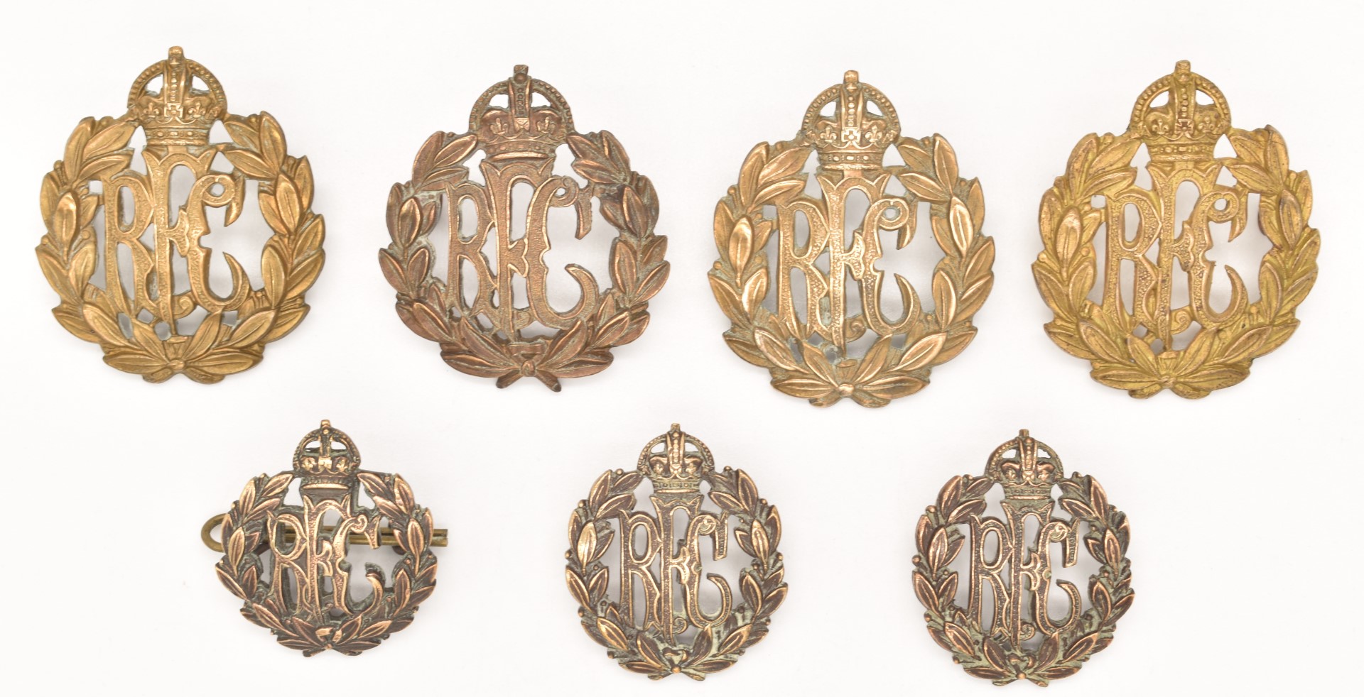 Seven WW1 Royal Flying Corps metal badges including a pair of collar badges, all with loops