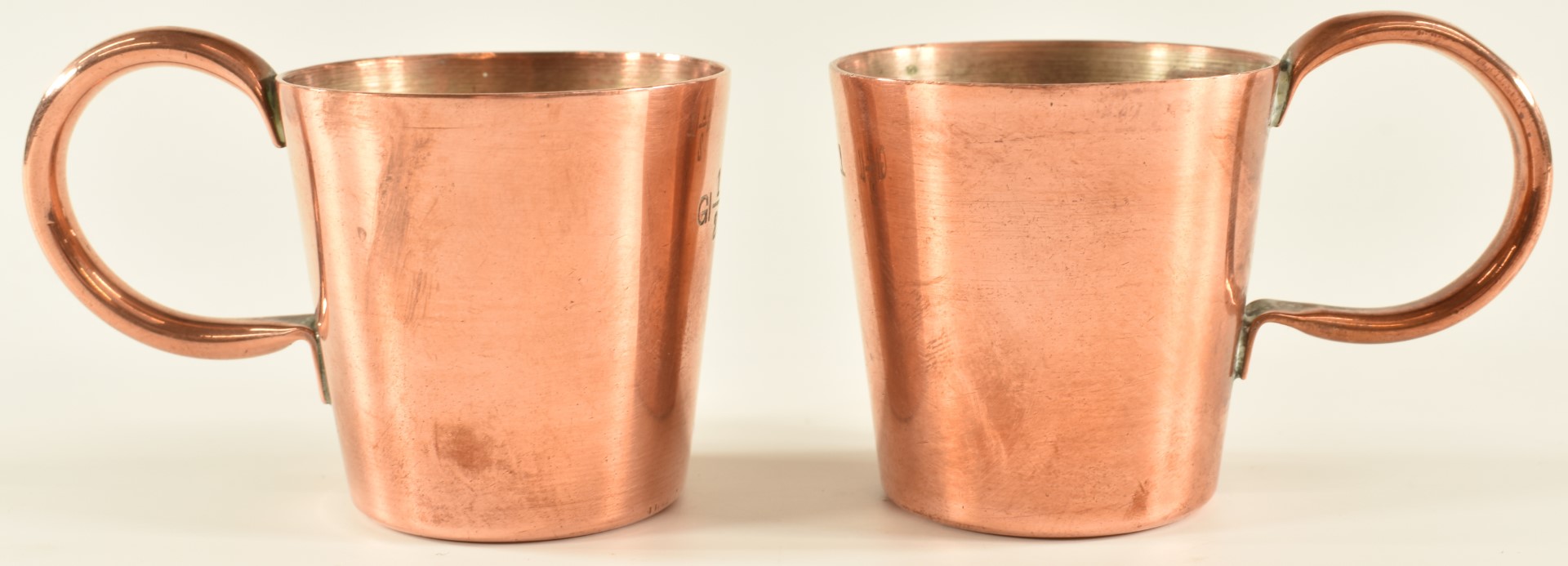 Pair of Royal Navy half gill copper rum measures with crown cipher and broad arrow marks to base