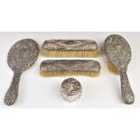 Edward VII hallmarked silver dressing table set comprising hand mirror and three various brushes,