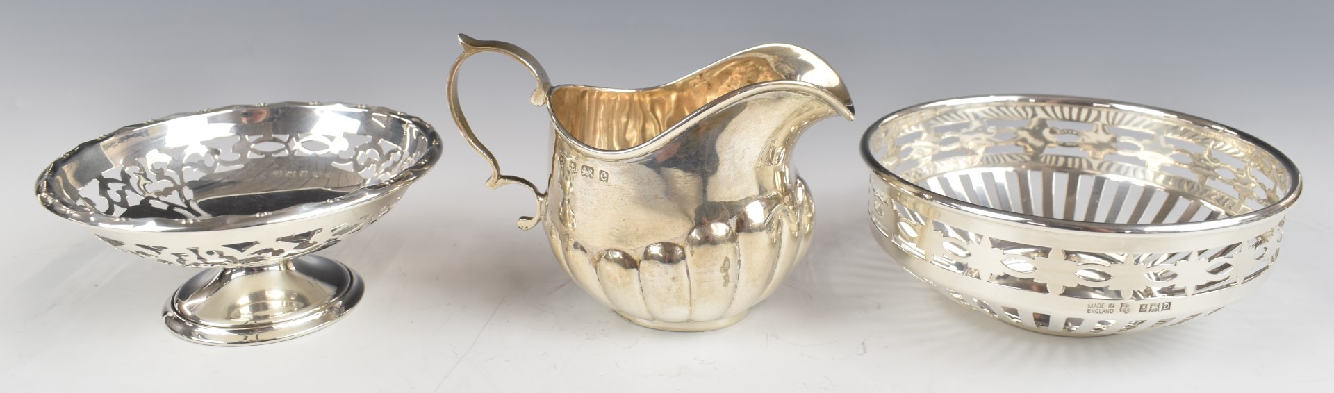 Three hallmarked silver items comprising pierced bowl, pedestal bowl and a milk jug, diameter of