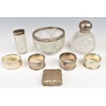 Four hallmarked silver napkin rings, three hallmarked silver mounted cut glass items, one Asrey, and