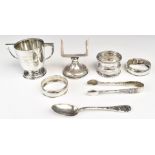 Hallmarked silver items comprising twin handled trophy cup, height 5.5cm, three various napkin