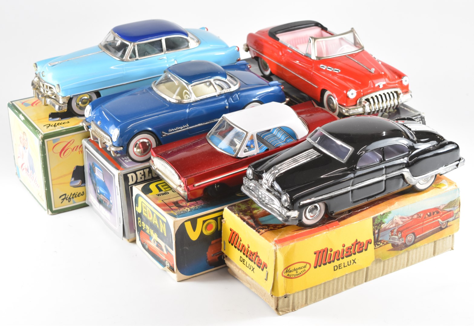 Five American style friction and clockwork tinplate cars including Cadillacs, all in original