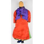 Chinese 'Door of Hope' doll wearing a pink dress and purple silk jacket, height 22cm