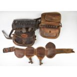 A collection of gun and shooting related items including leather cartridge bags, leather shot belt