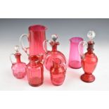 Seven pieces of cranberry glass including jugs, ewers and decanters, largest 29cm tall.