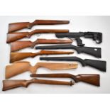 Ten various rifle stocks including BSA, one with a composite tactical stock.