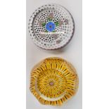 Two Perthshire glass paperweights, one with central blue and yellow flower surrounded by pink and