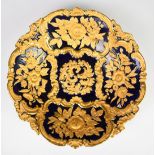 Meissen large shaped pedestal dish with relief moulded decoration of gilded flowers against a navy