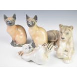 Four Copenhagen animal figures comprising recumbent lioness, Polar Bear cub and two Siamese cats,