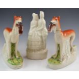 A pair of Staffordshire greyhounds with game, height 28cm and a figure of a soldier with sweetheart