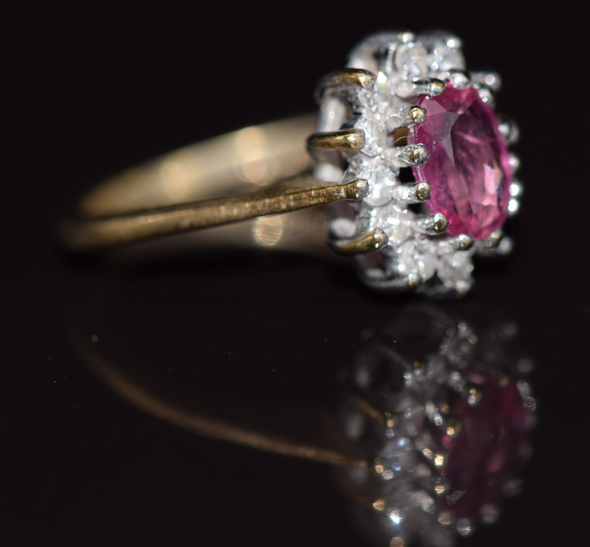 A 9ct gold ring set with an oval cut pink sapphire surrounded by diamonds, 1.7g, size E - Image 2 of 2