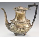 Victorian hallmarked silver hot water or coffee pot with reeded lower body, raised on four ball