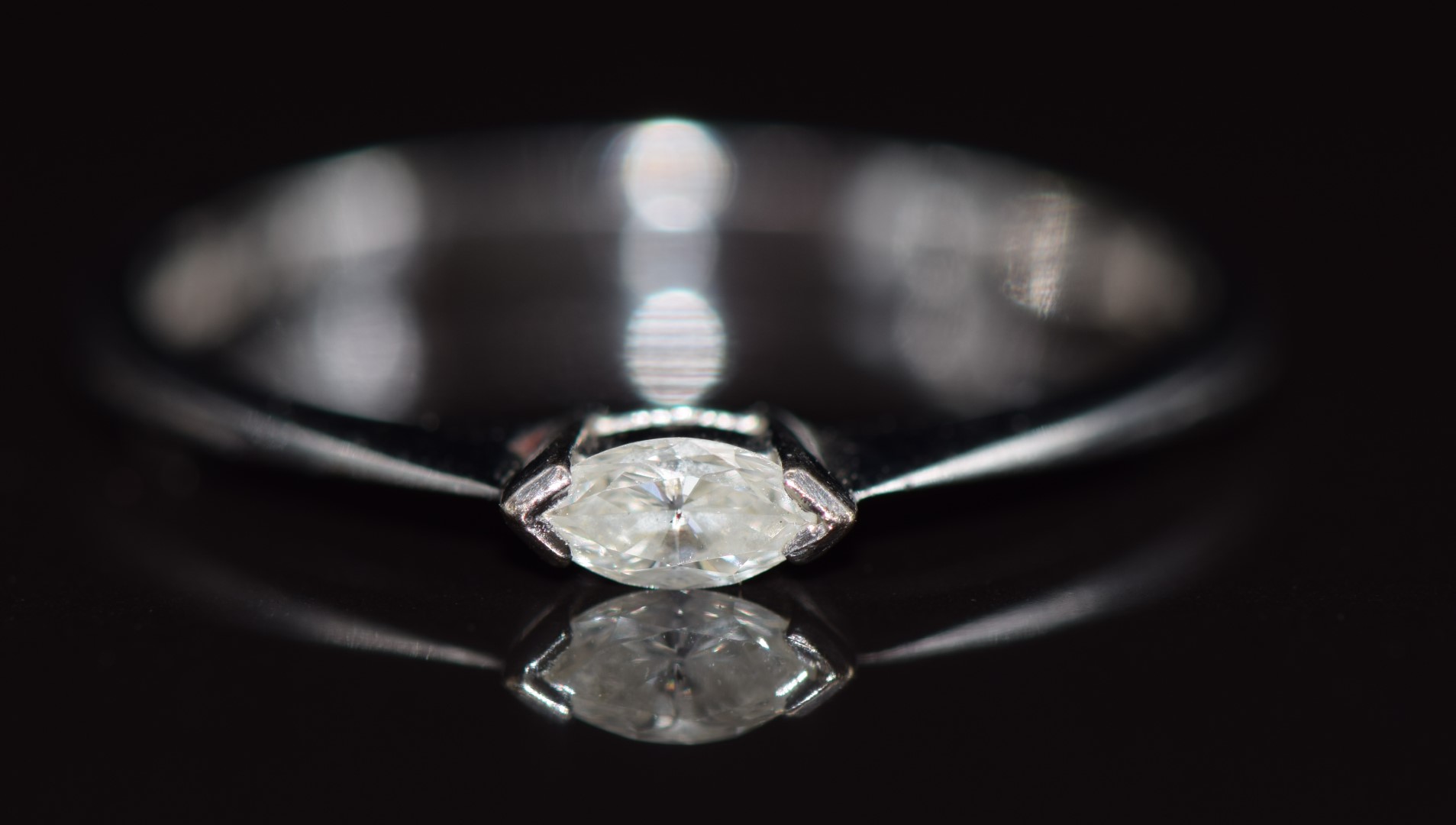 An 18ct white gold ring set with a marquise cut diamond, 1.4g, size L