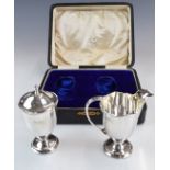 George V cased hallmarked silver strawberry set comprising cream jug and sugar sifter, in original