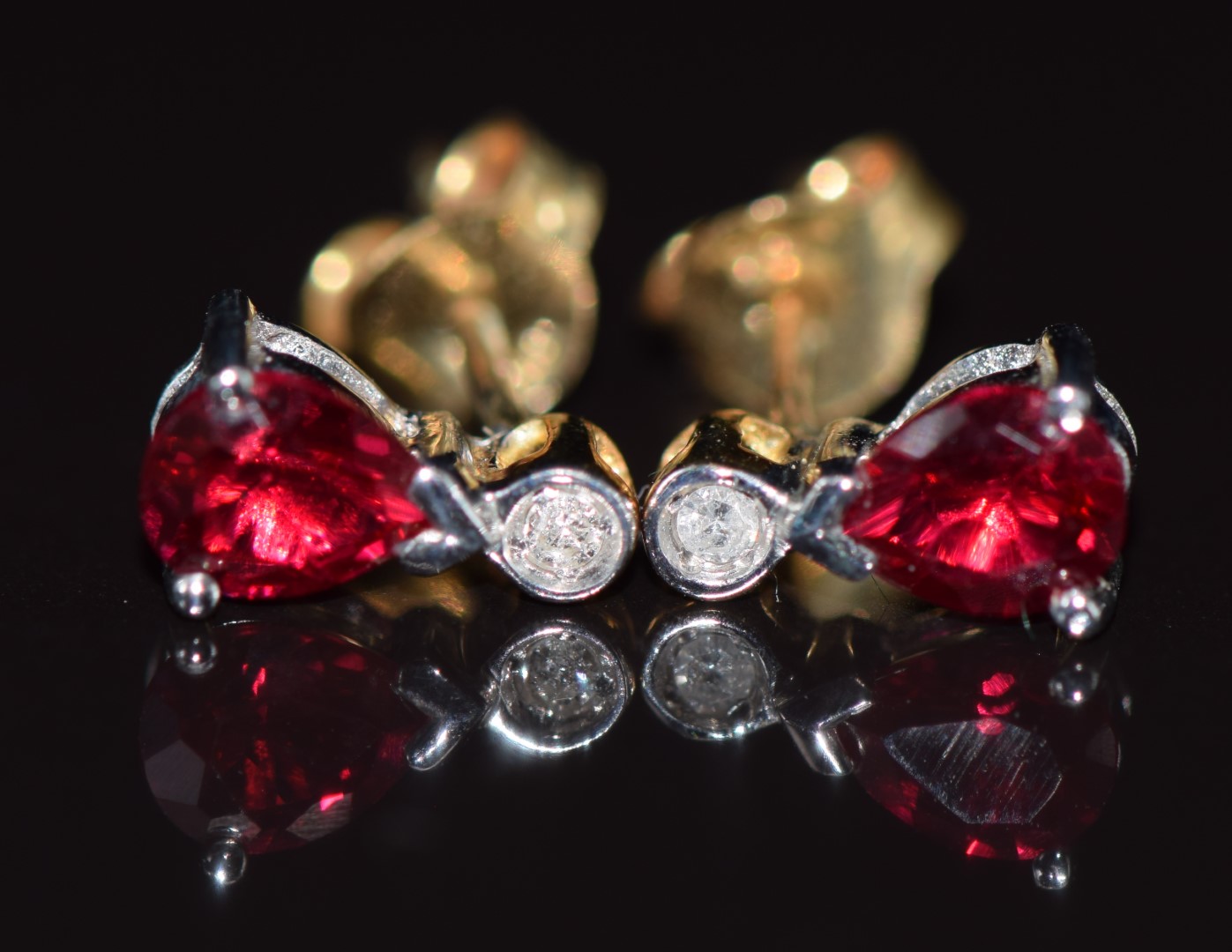 A pair of 9ct gold earrings set with a ruby and diamond, 1g