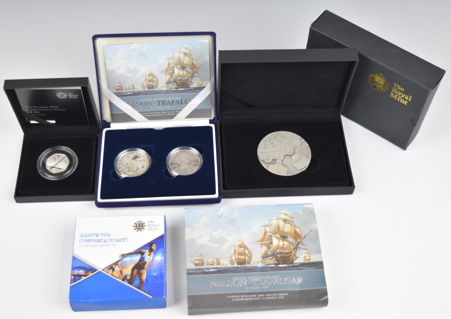 Four commemorative Royal Mint coins comprising a Glasgow Commonwealth Games silver proof 50p, a pair