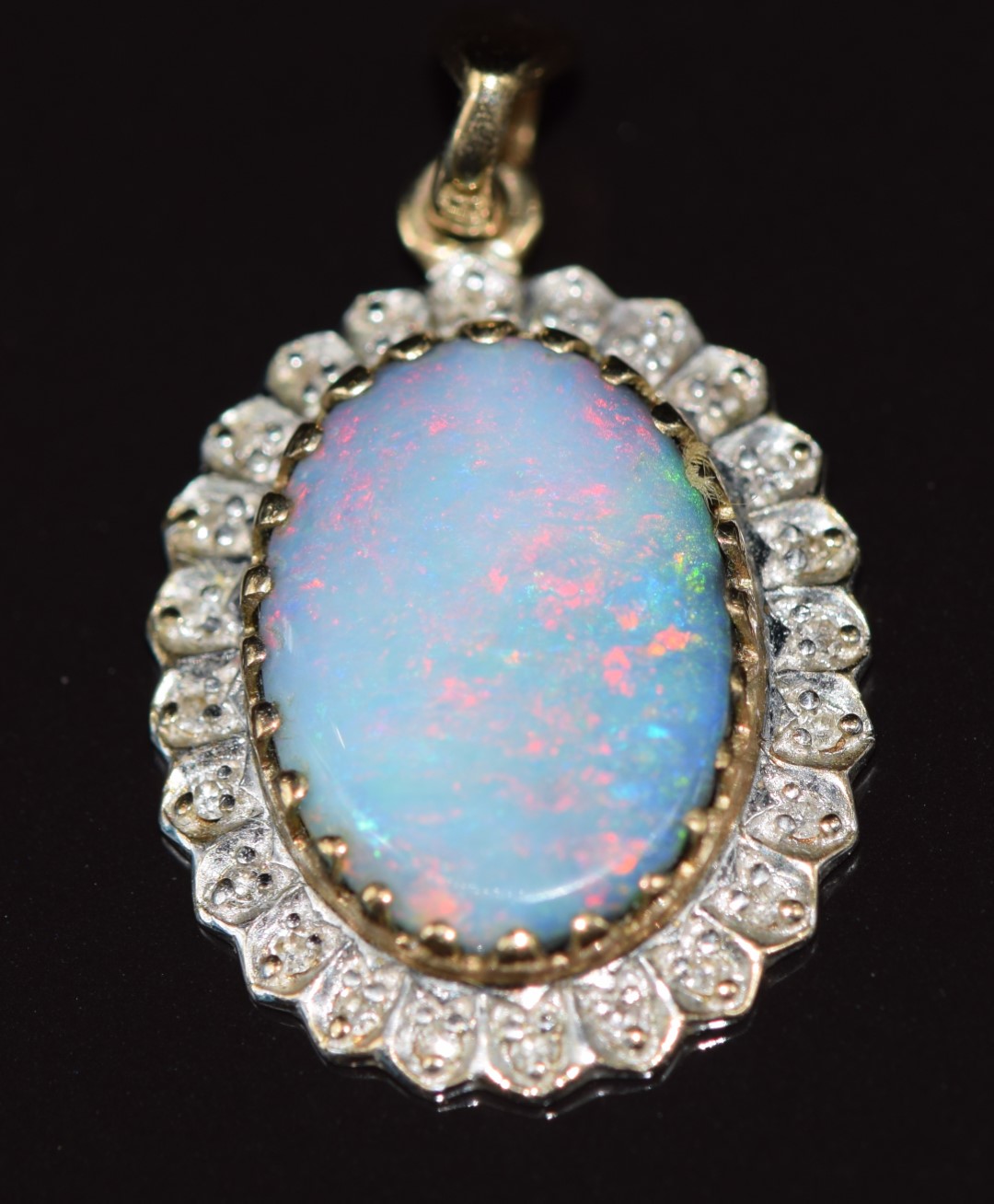 A 9ct gold pendant set with an opal surrounded by diamonds, 2.4g