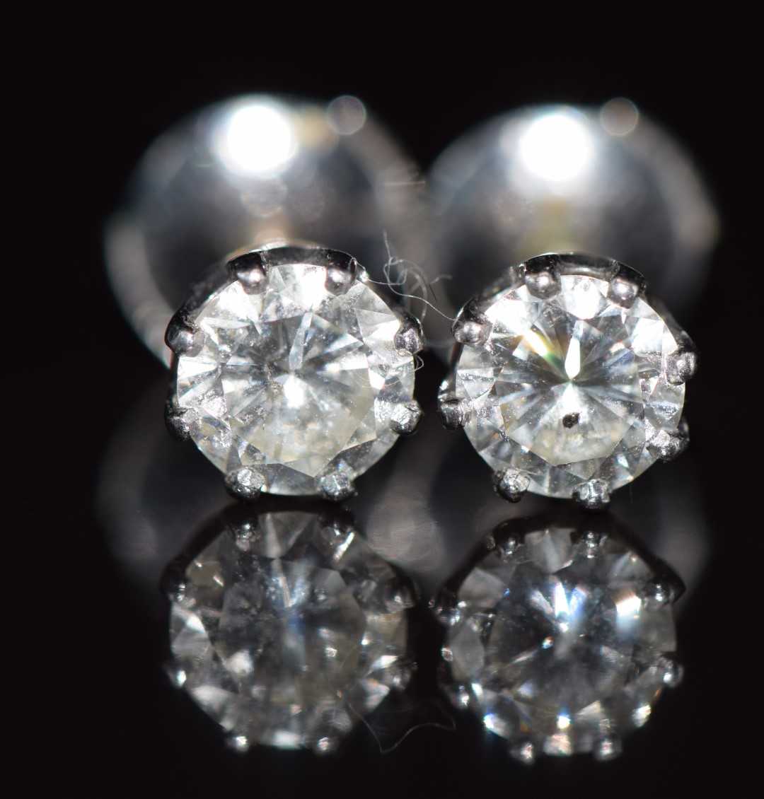 A pair of 18ct white gold earrings set with round cut diamonds of approximately 0.6 and 0.7ct, 2.
