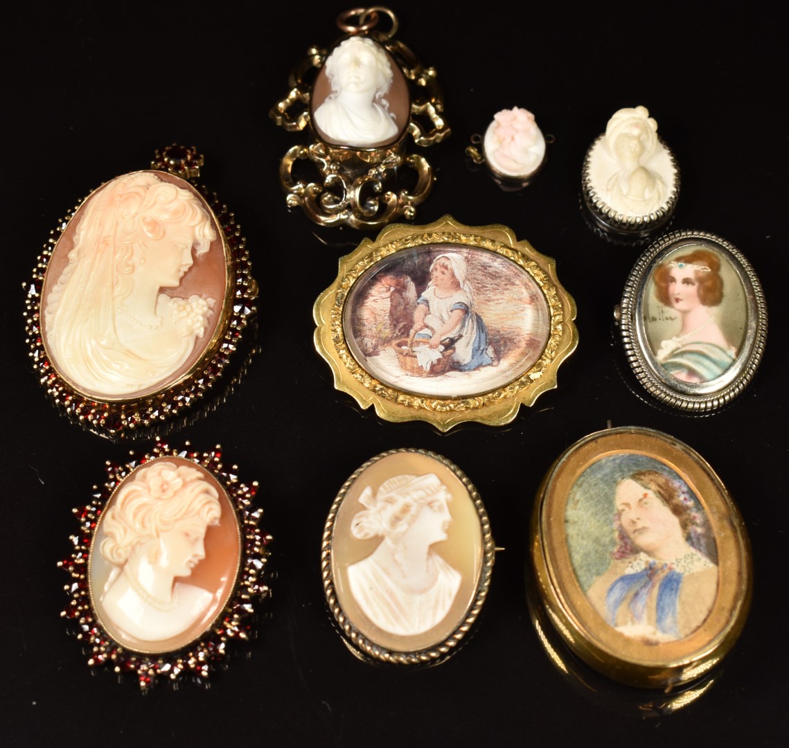 Two silver brooches each set with a cameo surrounded by Bohemiam cut garnets, a silver brooch set