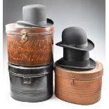 Three tin hat boxes containing silk top hat, bowler hat and a lady's riding hat, one tin with