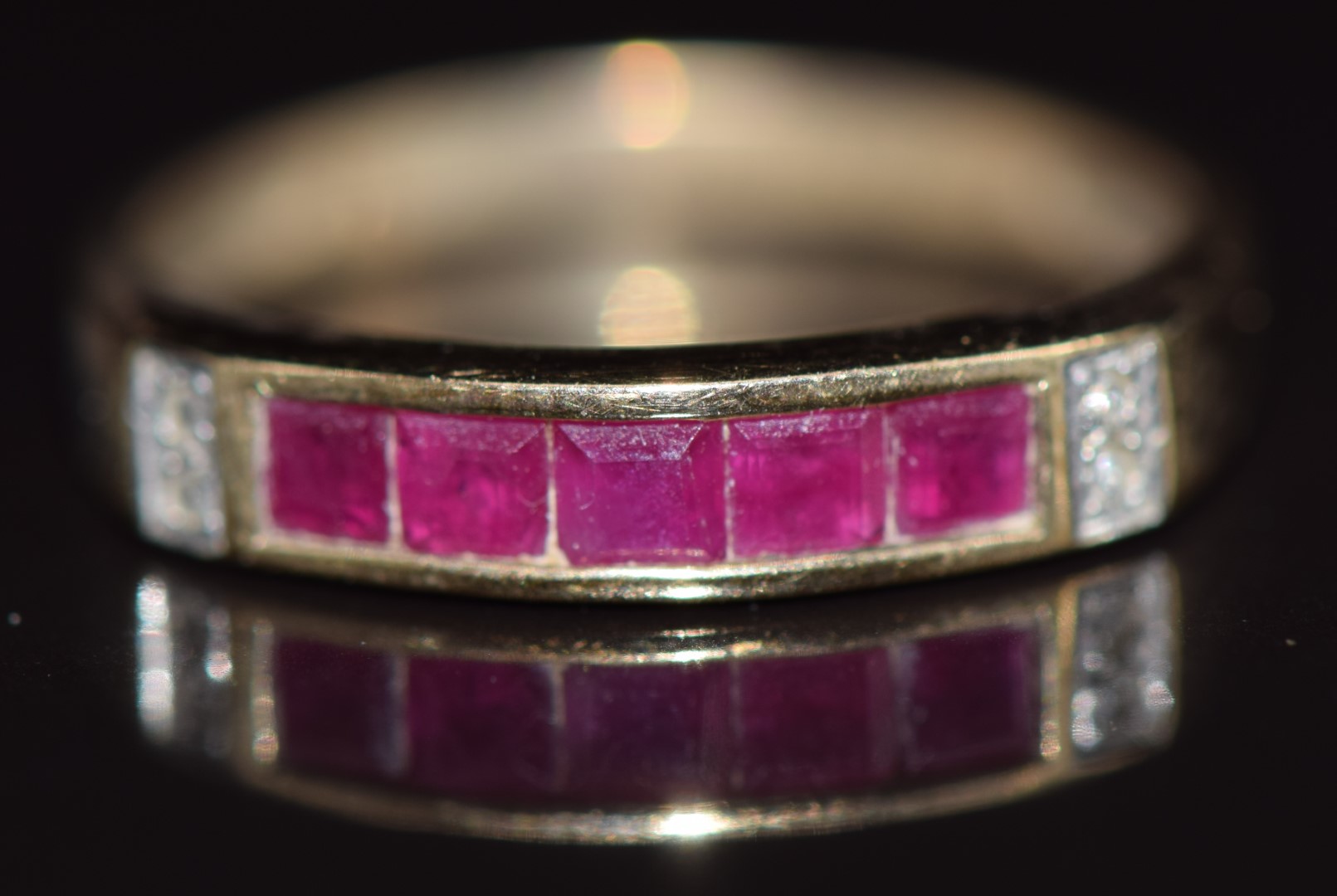 A 9ct gold ring set with calibre cut rubies and diamonds, 1.9g, size M