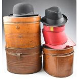 Three tin hat boxes including top hats, one with burgundy felt interior (exterior silk missing)