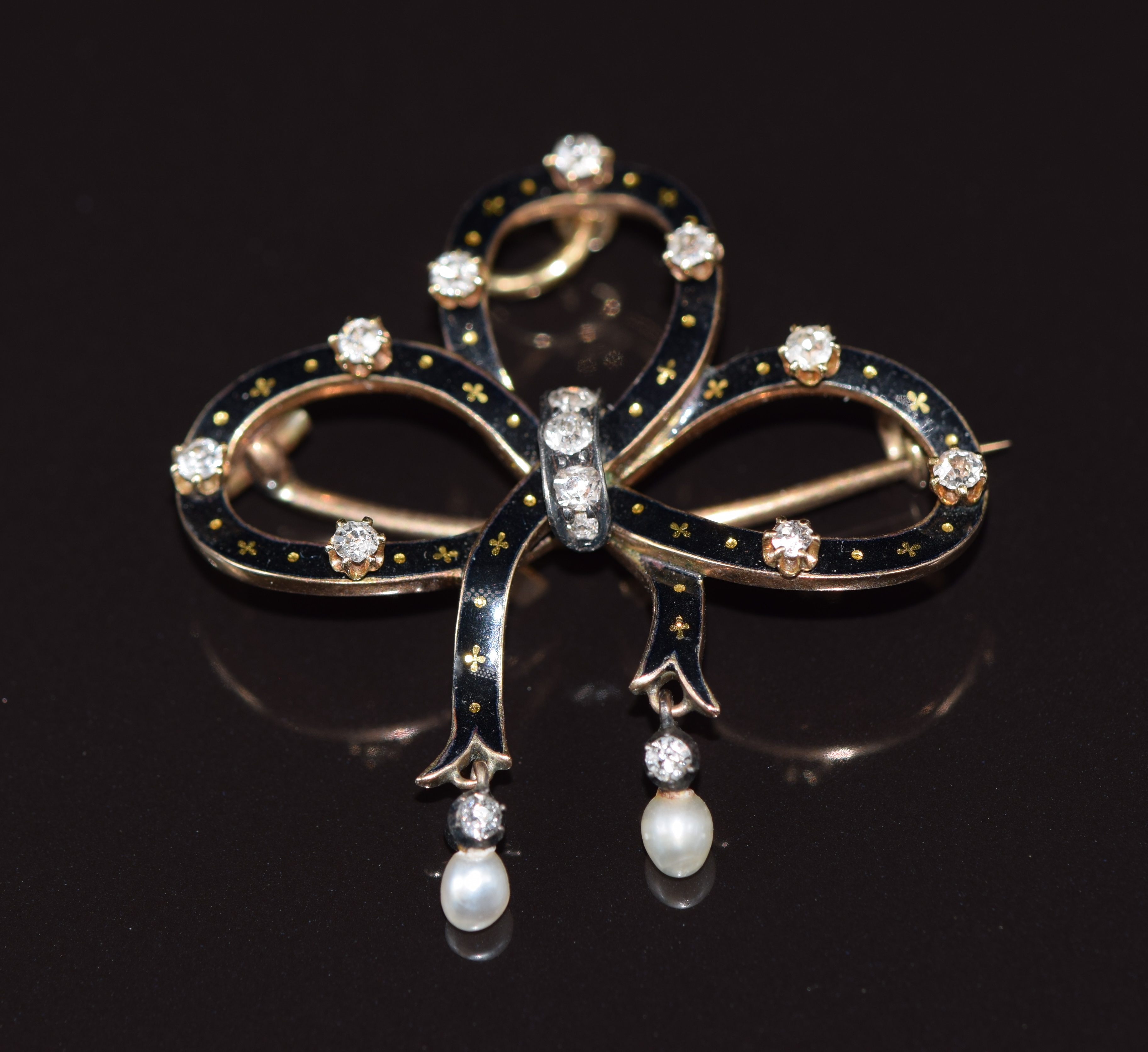 Victorian 9ct gold pendant/ brooch in the form of a bow set with enamel, diamonds and two drop