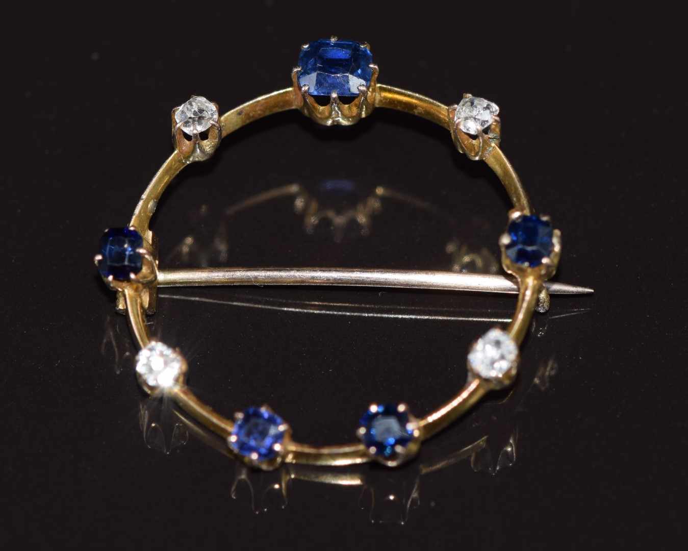 A c1915 9ct gold brooch set with sapphires and old cut diamonds, 2.7g 2.6cm