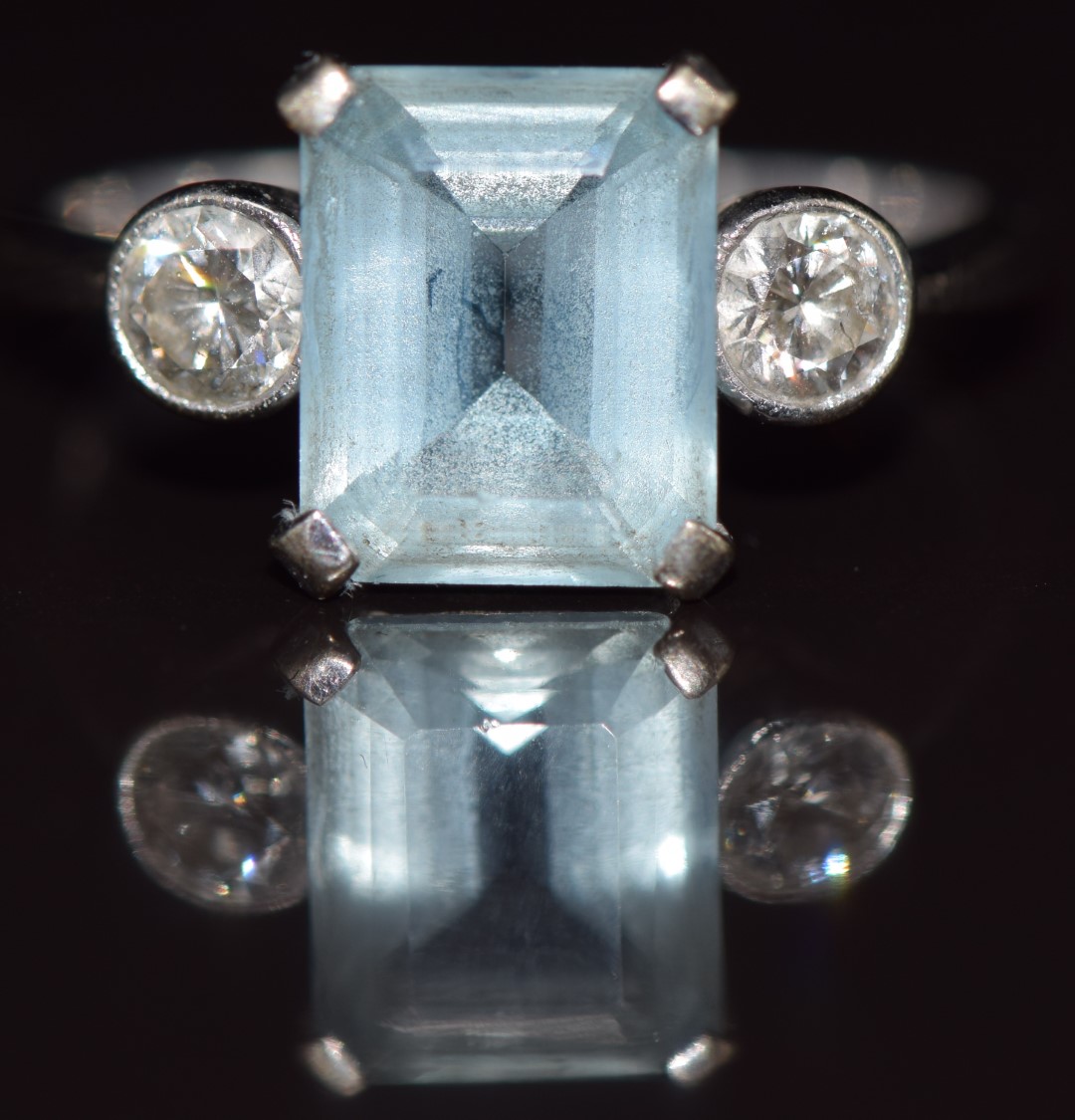 An 18ct white gold ring set with an emerald cut aquamarine of approximately 2.6ct and two