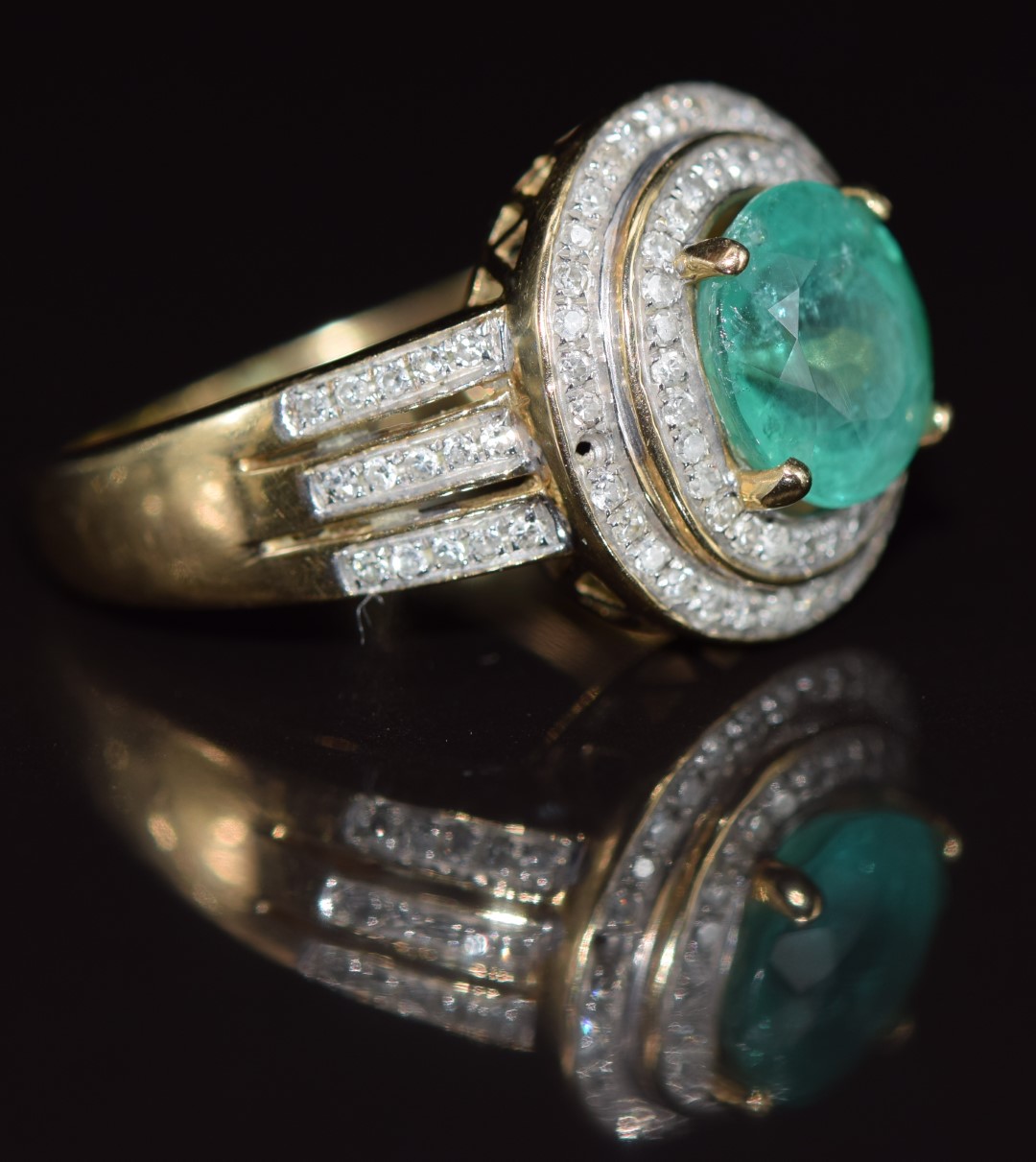 A 14k gold ring set with an oval cut emerald of approximately 1.8ct  surrounded by diamonds, 4.4g, - Image 3 of 3