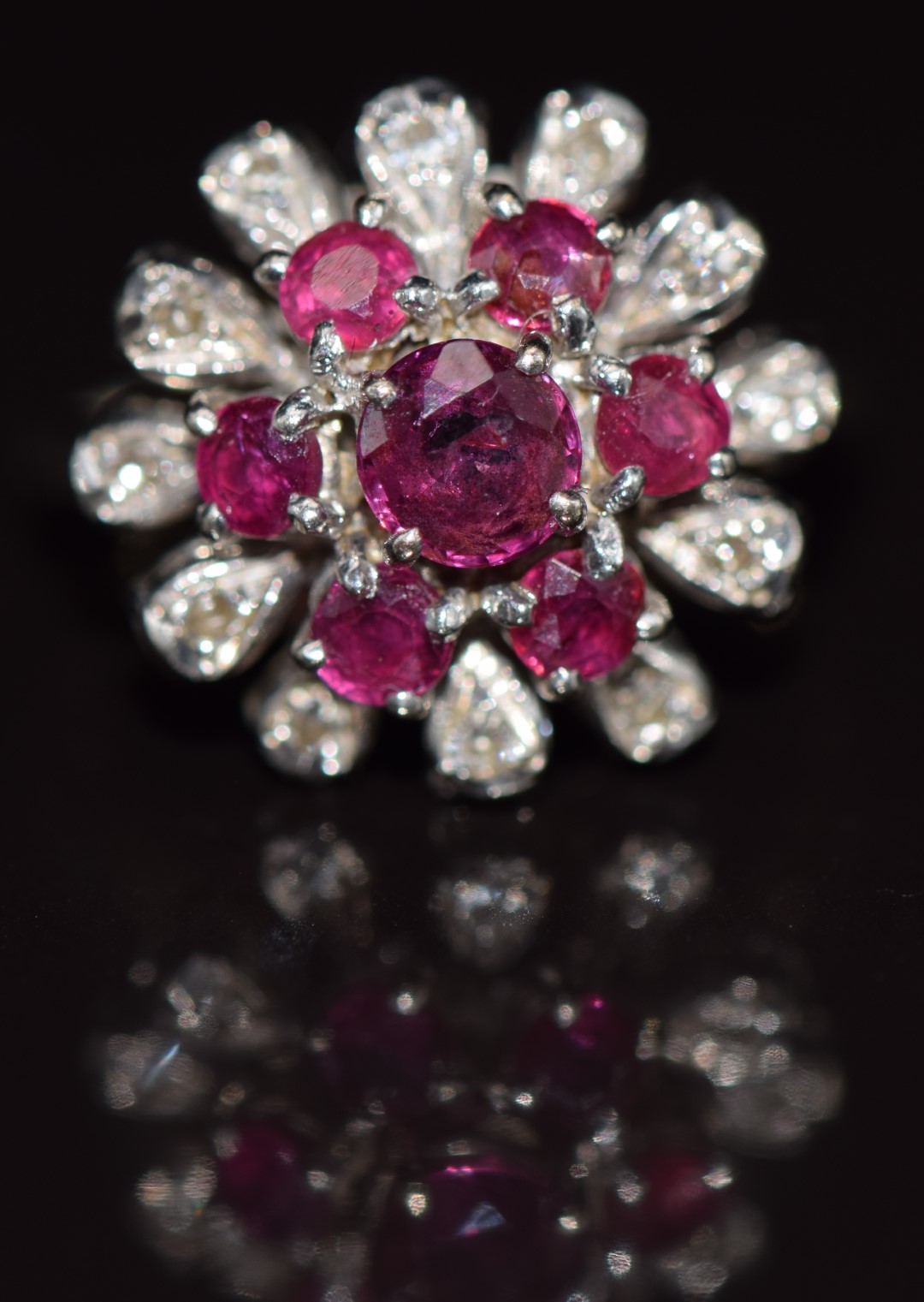 An 18ct white gold ring set with rubies and diamonds in a floral cluster, 5.1g, size I