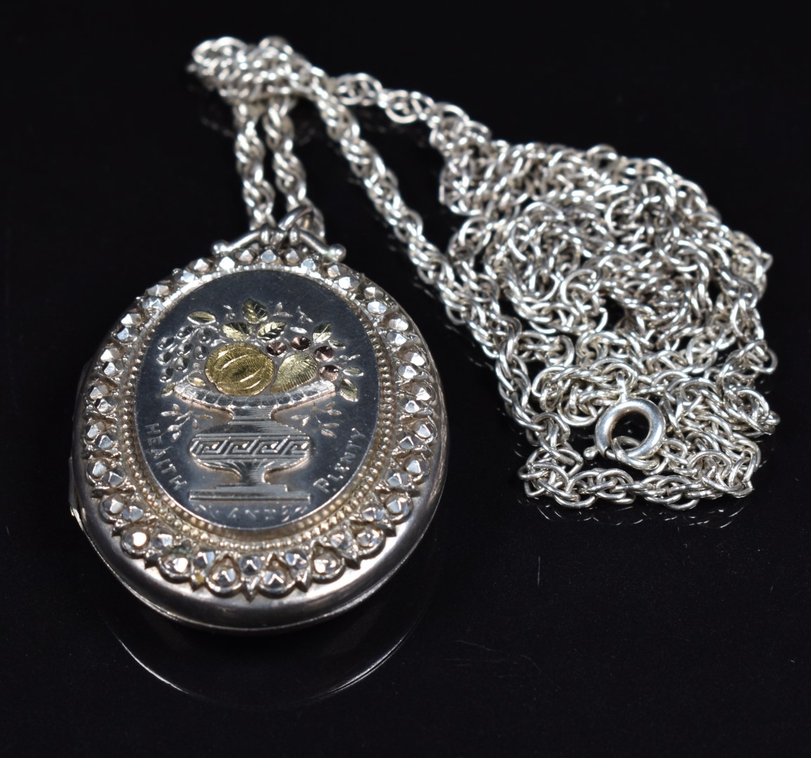 Victorian silver locket with applied gold decoration depicting an urn with fruit, engraved 'Health