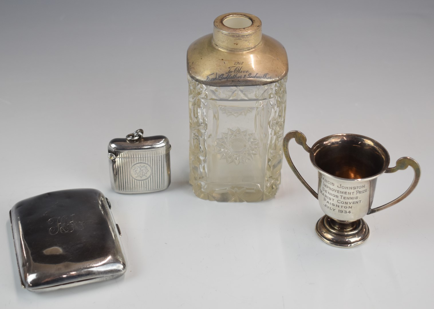 Hallmarked silver items comprising vesta case, cigarette case, miniature twin handled trophy cup and