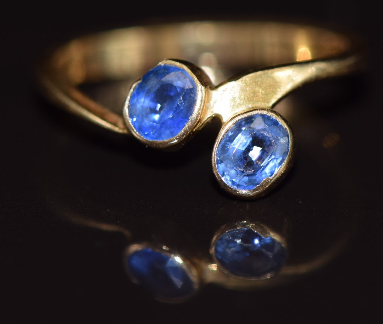 An 18ct gold ring set with two cornflower blue sapphires, 1.9g, size J