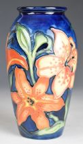 Moorcroft pottery baluster shaped vase with iris and lily decoration, height 18cm