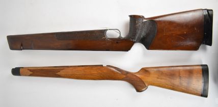 Two rifle stocks, one for an Anschutz target rifle with textured semi-pistol grip and forend, raised