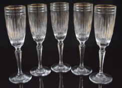 Five Waterford Crystal Marquis Hanover Gold champagne flutes with gilt rims, 22cm tall.