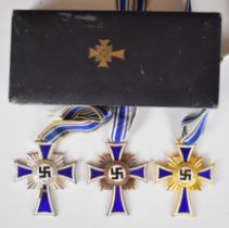 Three German Nazi Third Reich Mother's Cross medals comprising gold, silver and bronze examples, the