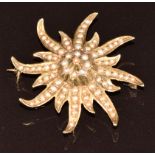 A 14k gold brooch set with seed pearls in a stylised star setting, 6.3g, 3.6cm